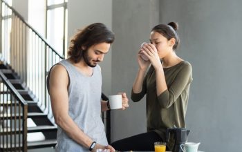 A couple enjoying a cozy breakfast with coffee and juice in their modern home kitchen.